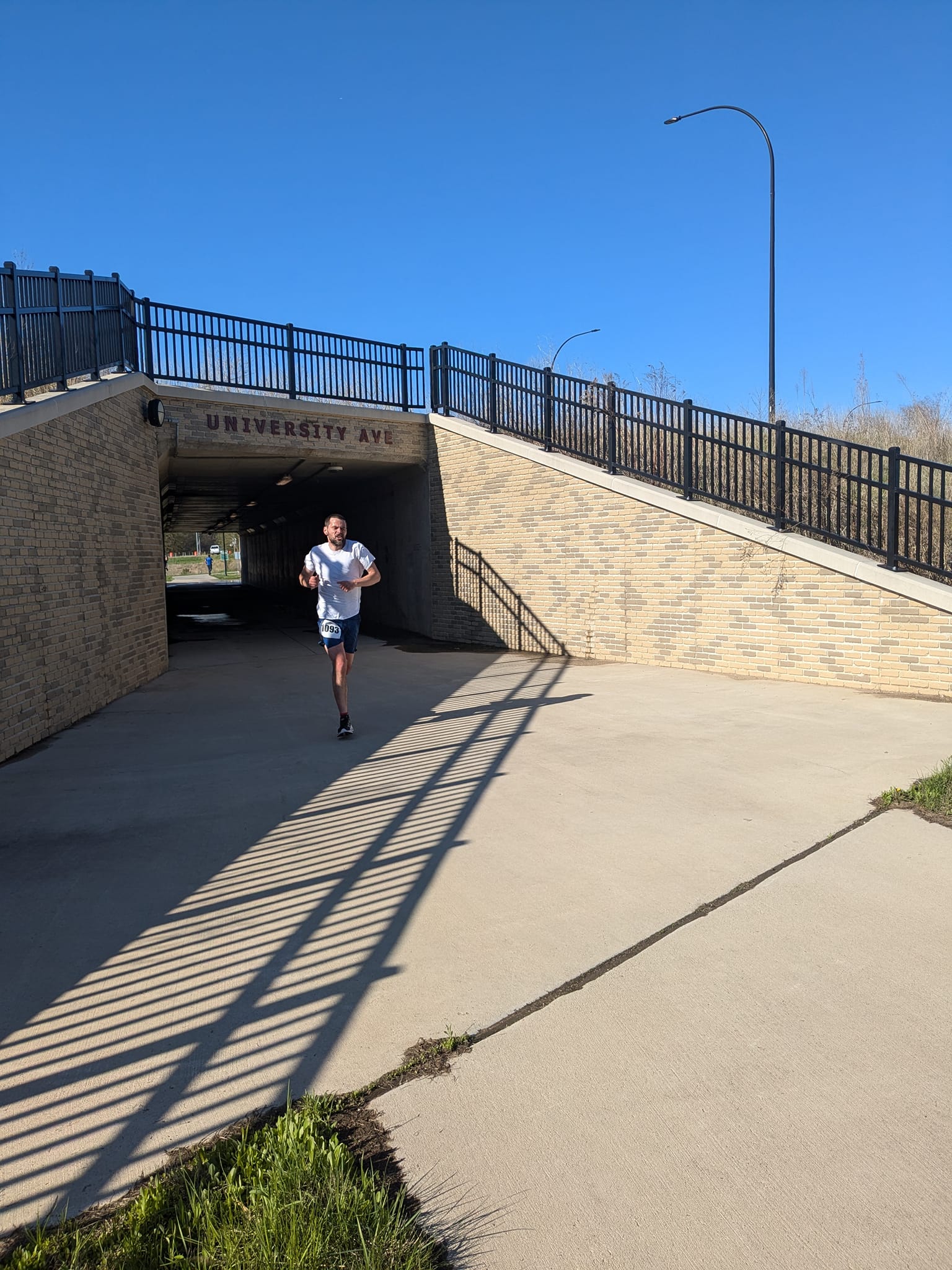 493916661_1227526092710957_1759711798908850988_n a photo of someone running under a bridge on a bike trail.