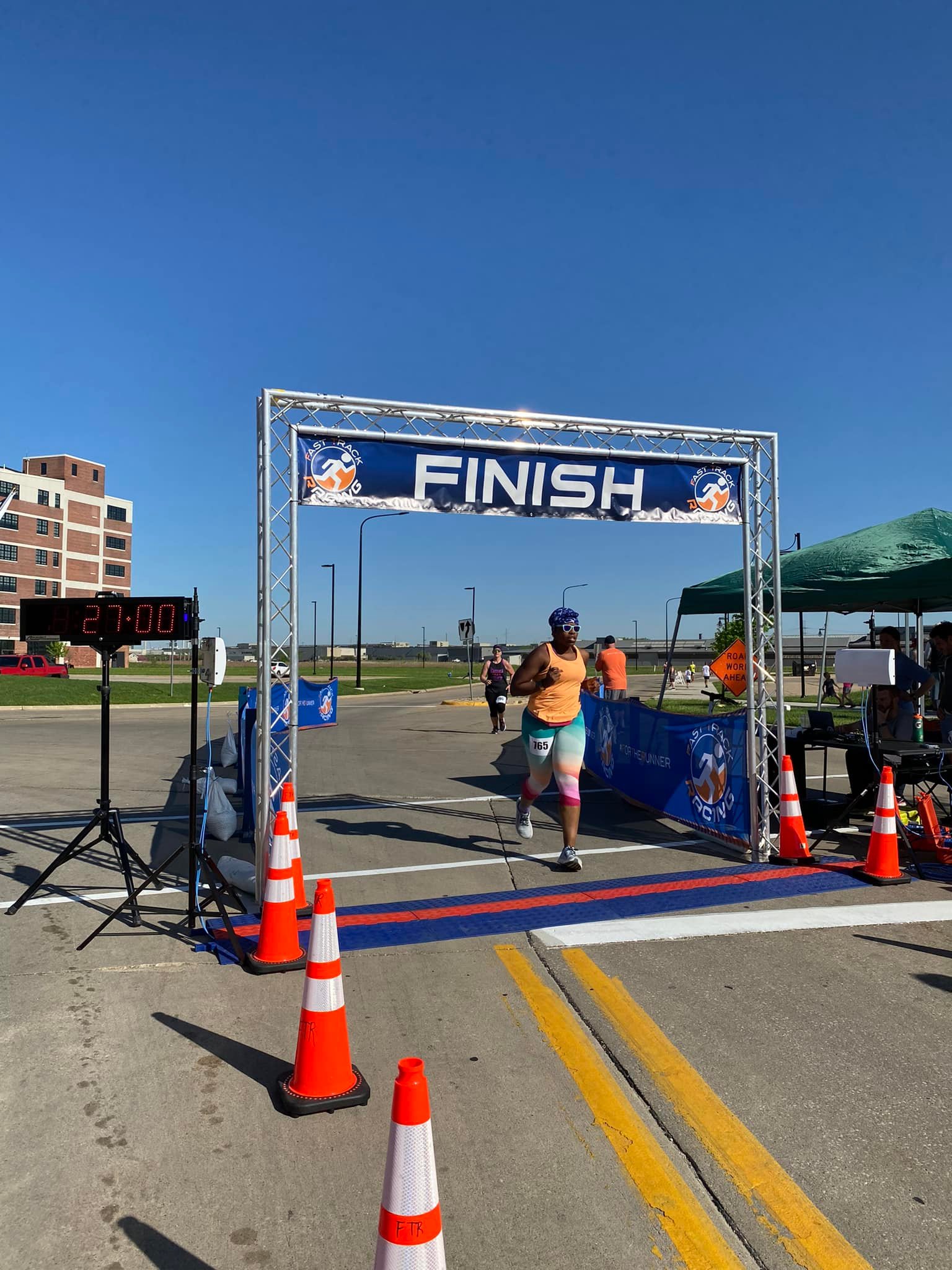 finishing photo a girl crossing a finish line with a truss that says finish.